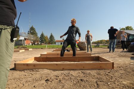 Ben Reinhold, Seth Doble, Charles Pol, and Beth Pol continue to work on the farm's new garden, as a crew member films. (National Geographic)