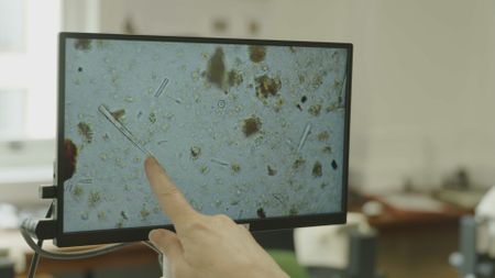 Anke Marsh a geoarchaeologist at University College London examines an ancient sample in the lab. (Windfall Films/Josh Rowley)