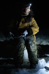 Iriqtaq Hailstone ice fishes with her family in the dark in hopes of catching a fish for their dinner. (BBC Studios Reality Productions, LLC/Dwayne Fowler)