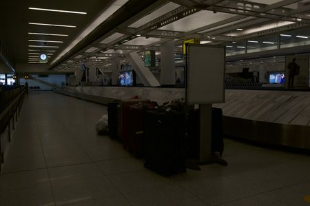 Multiple pieces of luggage are waiting near a baggage claim carousel at the JFK International Airport. (National Geographic)