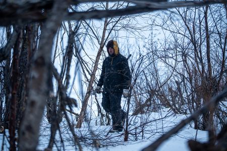 Chevie Roach gathers branches to build a blind during the migratory water fowl hunting season. (BBC Studios Reality Productions/Jayce Kolinski)