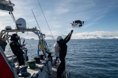 Crew launch a filming drone by hand to avoid collision with the rigging on the yacht. (National Geographic for Disney/Kenneth Perdigon)