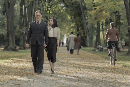 A SMALL LIGHT - Jan and Miep Gies, played by Joe Cole and Bel Powley, walk through a park as seen in A SMALL LIGHT. (Credit: National Geographic for Disney/Dusan Martincek)