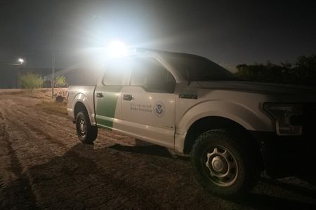 A Border Patrol vehicle is parked on a road near the border wall in the Rio Grande Valley, Texas. (National Geographic)