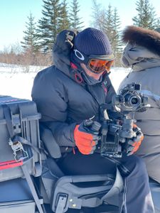 Director of photography Simon Niblett checks his camera on the back of a Skidoo. (National Geographic for Disney/Duncan Chard)