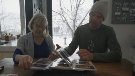 Big Mountain Snowboarder Travis Rice, right, and his mother, Becky Rice, look over childhood photos.(photo credit: National Geographic/Ross McDonnell)