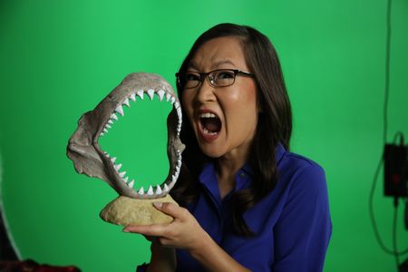 Helen Hong mimicking a big bite with a display shark jaw. (National Geographic/Robert Toth)