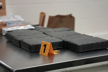 Multiple packages of suspected narcotics are sitting on an inspection table after they were discovered hidden in a suspect's vehicle in Brownsville, Texas. (National Geographic)