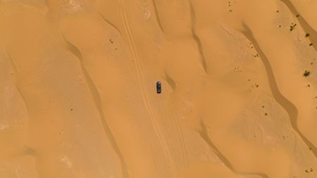 A car moves through the desert in Erg Chebbi Dunes, Morocco. (National Geographic for Disney/Jonjo Harrington)