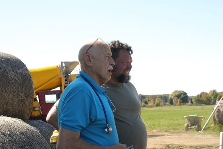 Dr. Pol and Charles Pol look at the farm's sheep hut while brainstorming ideas to drain the sheep's excrements. (National Geographic)