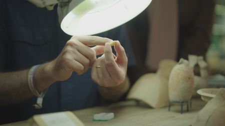 Ido Koch examines a stamp seal found at Tel Hadid, Israel in Tel Aviv, Israel. (Windfall Films/Nava Mizrahi)