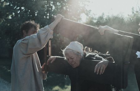 Janet Liston cries as two men close a pillory on her head and hands. (Dash Productions Services LTD/Antoan Ivanov)