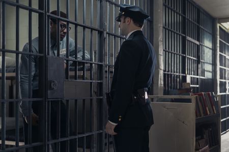 Malcolm X, played by Aaron Pierre, talks with a prison guard in GENIUS: MLK/X. (National Geographic/Richard DuCree)