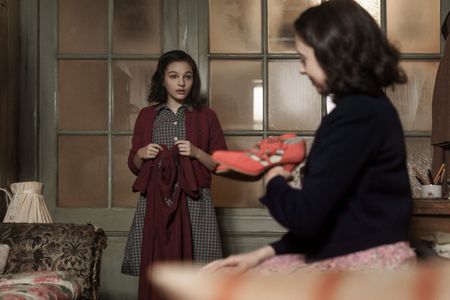 A SMALL LIGHT - Anne, played by Billie Boullet, receives a gift from Miep, played by Bel Powley, in A SMALL LIGHT. (Credit: National Geographic for Disney/Dusan Martincek)