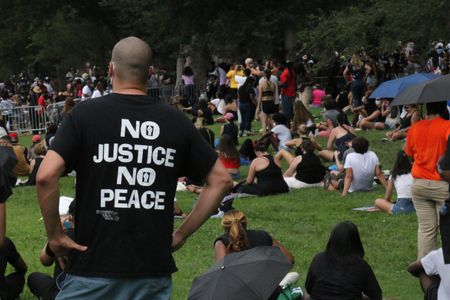 Man with his back to the camera has a t-shirt that reads, "No Justice No Peace" at the 2020 March on Washington.   (National Geographic/Drew Jones)
