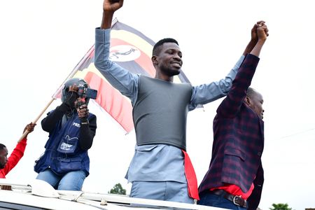 Bobi Wine and a prospective candidate running for the position of member of parliament under the National Unity Platform cheer on their supporters during one of the campaign sessions,  November 25, 2020. The campaigns have been marred by violence toward the opposition candidates and their supporters.   (photo credit: Lookman Kampala)