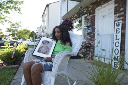 Doreen Stevens holds a photograph of her father, Johnnie Stevens, while seated outside her home in New Jersey.  Staff Sergeant Johnnie Stevens was a tank commander with the 761st Black Panther Tank Battalion who served in WW2.  (National Geographic/Fabian Mandujano)