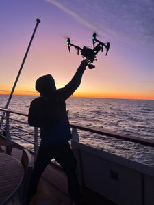 Drone Operator Raphael Boudreault-Simard  catches a drone on the deck of the expedition ship. (National Geographic for Disney/Ruth Davies)