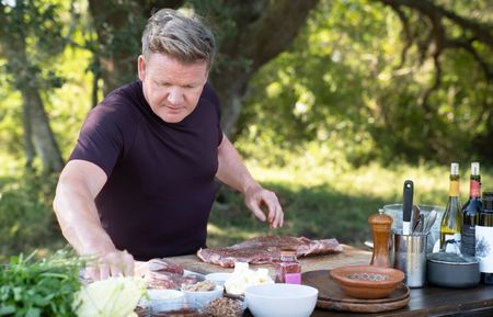 TX - Gordon Ramsay adds a dry rub to ribs before grilling them during the final cook in Texas. (Credit: National Geographic/Justin Mandel)