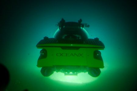 Headlights from the submarine light up the dark water off Svalbard, Norway. (National Geographic/Mario Tadinac)