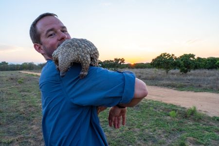 Giles Clark and Archie the baby pangolin. (National Geographic/Mark Challender)