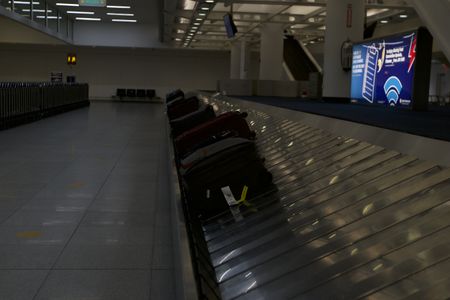 Multiple pieces of luggage are waiting on a baggage claim carousel at the JFK International Airport.(National Geographic)