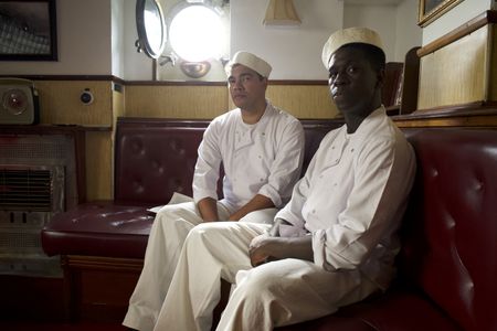 George Bland and Doris Miller (played by Daniel Abbott and Abdul Sulaiman, respectively) pose together in a WW2 historic reenactment scene for "Erased: WW2's Heroes of Color. The series tells the stories of three Black heroes who miraculously survived the attack on Pearl Harbor. Bland and Miller served as mess attendants on the USS West Virginia, and Miller defied racial stereotypes when he shot down enemy planes during the attack. (National Geographic/Seye Isikalu)