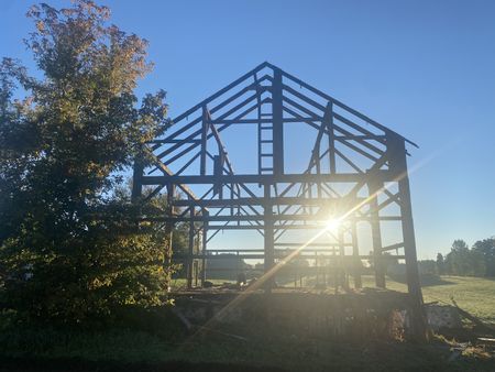 The sun sets on the framework of the historic barn the Pol family is taking down to transport and restore on the Pol family's farm. (National Geographic)