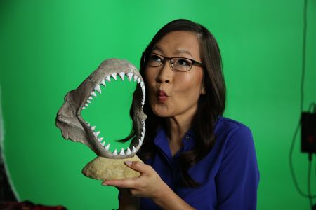 Helen Hong doing a kissy face while holding a display shark jaw. (National Geographic/Robert Toth)