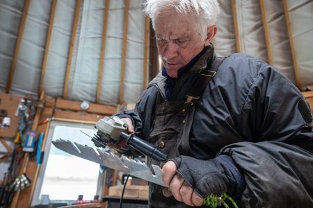 Andy Bassich creates a snow saw that will help him build a snow shelter for himself and his partner, Denise. (BBC Studios Reality Productions/Ben Mullin)