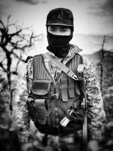 A masked narco stands guard with a rifle in Sinaloa mountains. (Nick Quested)