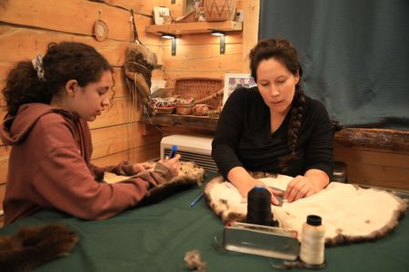 Sonta Roach teaching her daughter Sydney how to make mittens out of beaver fur. (BBC Studios Reality Productions, LLC/Brian Bitterfeld)