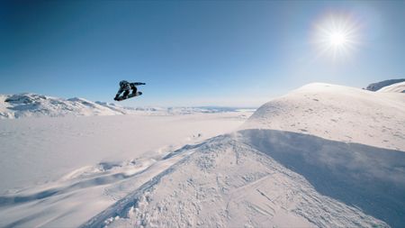 Travis Rice jumps as he snowboards on a mountain in Alaska.  (photo credit: Red Bull Media House)