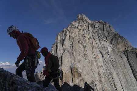 Tommy Caldwell and Alex Honnold walking uphill, silhouetted against a mountain in Bugaboo Provinical Park.  (National Geographic/Taylor Shaffer)