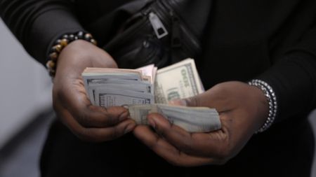 A traveler counts the stack of currency they are traveling with in Dulles, Va. (National Geographic)