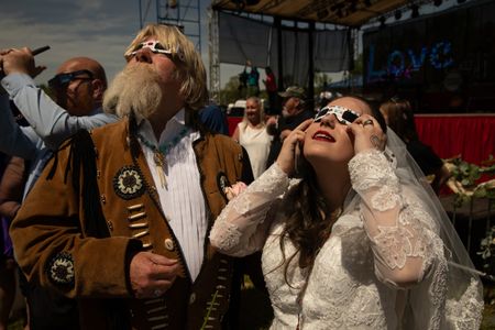 William “Bill” Hyde and Angelica Grimes watch the solar eclipse. The mass elopement took place during the Total Eclipse of the Heart festival. Couples needed only a marriage license to participate. The officiant, ceremony, and even a toast was provided. (Credit: Aaron Huey)