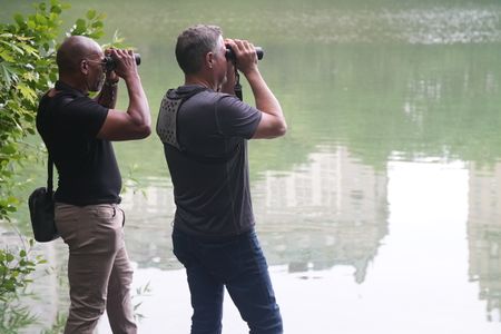 Christian Cooper and his friend, biologist and wildlife conservationist Jeff Corwin, look through binoculars across Central Park Lake. (National Geographic/Troy Christopher)