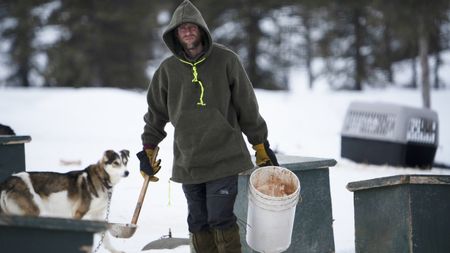 Jessie Holmes feeds his dog team around his home. (BBC Studios Reality Productions, LLC/JR Masters)