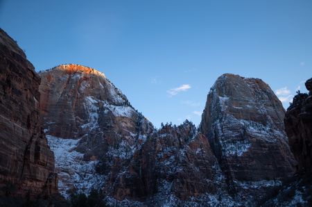 The rising sun lights up the top of a snow-dusted cliff.  (National Geographic/Jeff Reed)