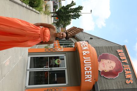BLACK TRAVEL ACROSS AMERICA - Host, Martinique Lewis poses outside of the popular black-owned juicery in Kansas City, Ruby Jean's Juicery. (National Geographic for Disney/Victoria Donfor)