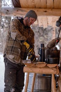 Johnny Rolfe builds his dog Java a box seat that will attach to his sled.   (BBC Studios Reality Production/Patrick Henderson)