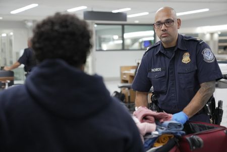 CBP Officer Mccants questions a passenger while going through their belongings in Atlanta, Ga. (National Geographic)