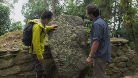 Albert Lin and Santiago Giraldo stand next to the stone map in Ciuadad Perdida. (National Geographic)