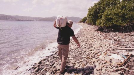 CBP AMO Agent Jeff carries a bale on his shoulders.  (Lucky 8 TV/Sharon Manente)