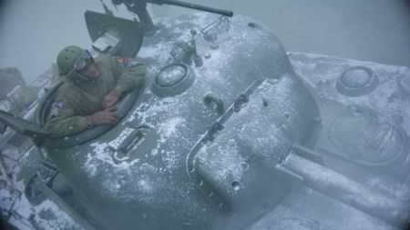 Staff Sergeant Johnnie Stevens (played by Juwon Adedokun) looks out of the tank in heavy snow, during the treacherous journey to Tillet, in a historic reenactment produced for "Erased: WW2's Heroes of Color." Staff Sergeant Stevens was a tank commander with the 761st Black Panther Tank Battalion who served in WW2. (National Geographic)