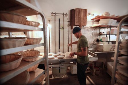 Josey Baker prepares baking goods at his bakery, The Mill, in San Francisco. (National Geographic/Ryan Rothmaier)