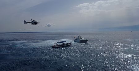 Two boats and a helicopter from the Guardia Civil are pictured during a police operation in Majorca, Balearic Islands, Spain. (National Geographic/Jose Antonio Gavilán Tobal)