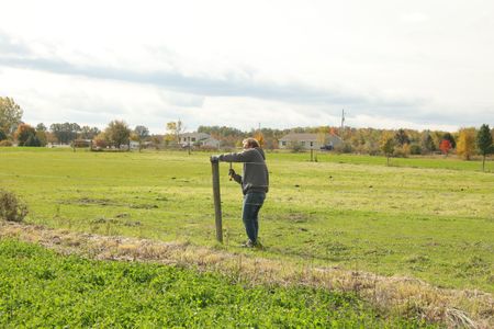 Ben Reinhold fixes one of the posts supporting the Pol family farm's animal pasture fencing. (National Geographic)