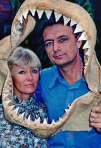 Ron & Valerie Taylor framed by a shark jaw skeleton.  (photo credit: Ron & Valerie Taylor)