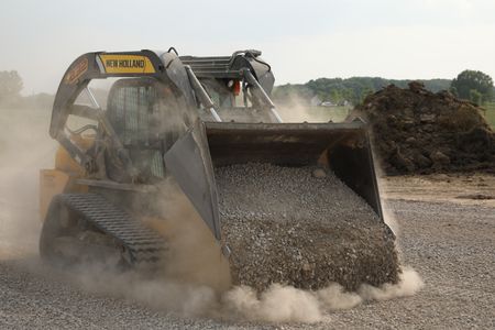 Ben Reinhold drives a compact track loader full of gravel while working on a swale to prevent flooding around the sheep hut. (National Geographic)